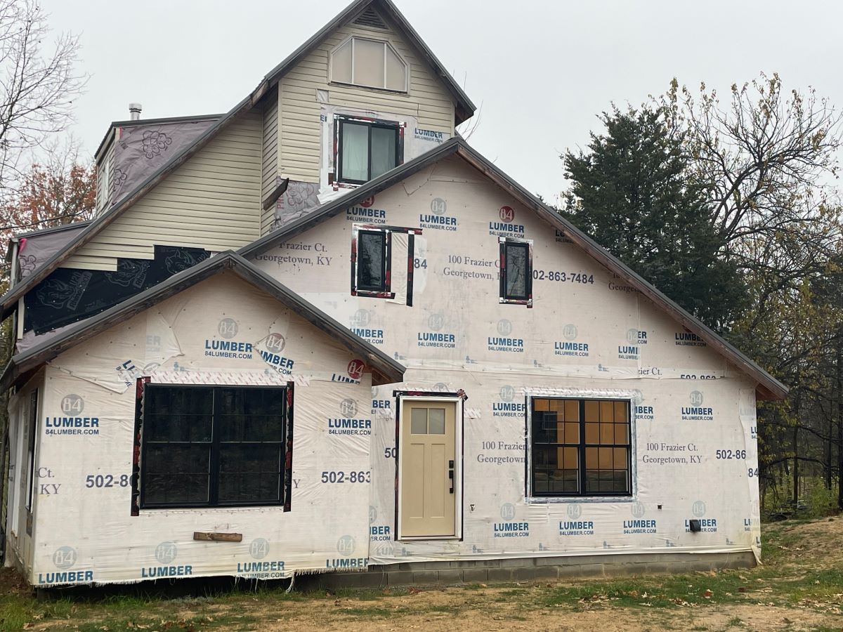 Two-story house under construction with exposed insulation.